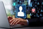 AdobeStock_1364130553-c-tadamichi Computer mit tippenden Händen, von einem Button gehen Linien zu Symbolen wie Handy, Herz und Einkaufswagen.