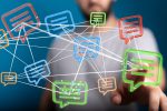 AdobeStock_1518350593-c-vegefox Ein Mann tippt mit dem Finger auf ein Symbol in einem Netz aus Kommunikationssymbolen.