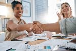 Meeting, handshake and collaboration with a business black woman in the office for a deal or agreement. Teamwork, collaboration and thank you with a female employee shaking hands with a colleague.