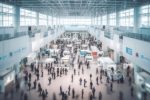 Luftaufnahme einer Messe mit vielen Menschen und Ständen.