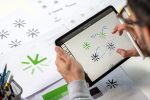 Tablet zeigt verschiedene Logo-Varianten, Skizzen und Notizen.