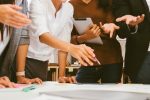 Projektbesprechung im Team, Personen in Business-Kleidung gestikulieren.